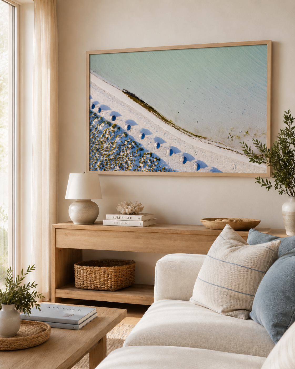 Costa Serena fotografía costera aérea enmarcada en sala minimalista con tonos neutros y madera natural