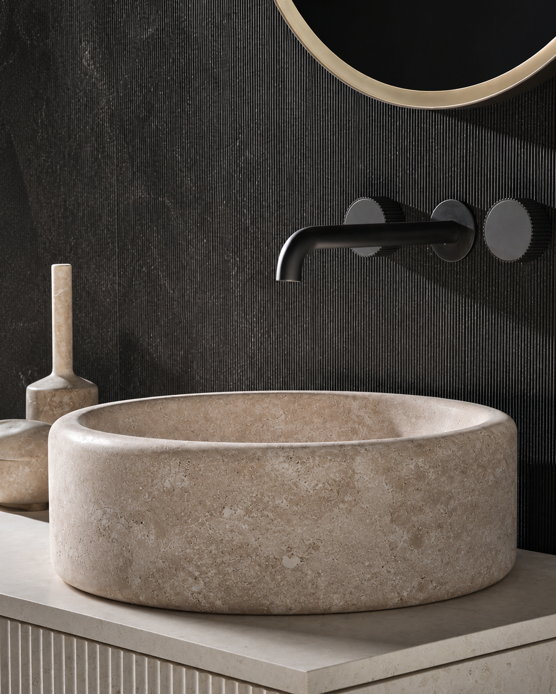Ovalín redondo de piedra natural instalado en baño contemporáneo con muro negro y grifería negra